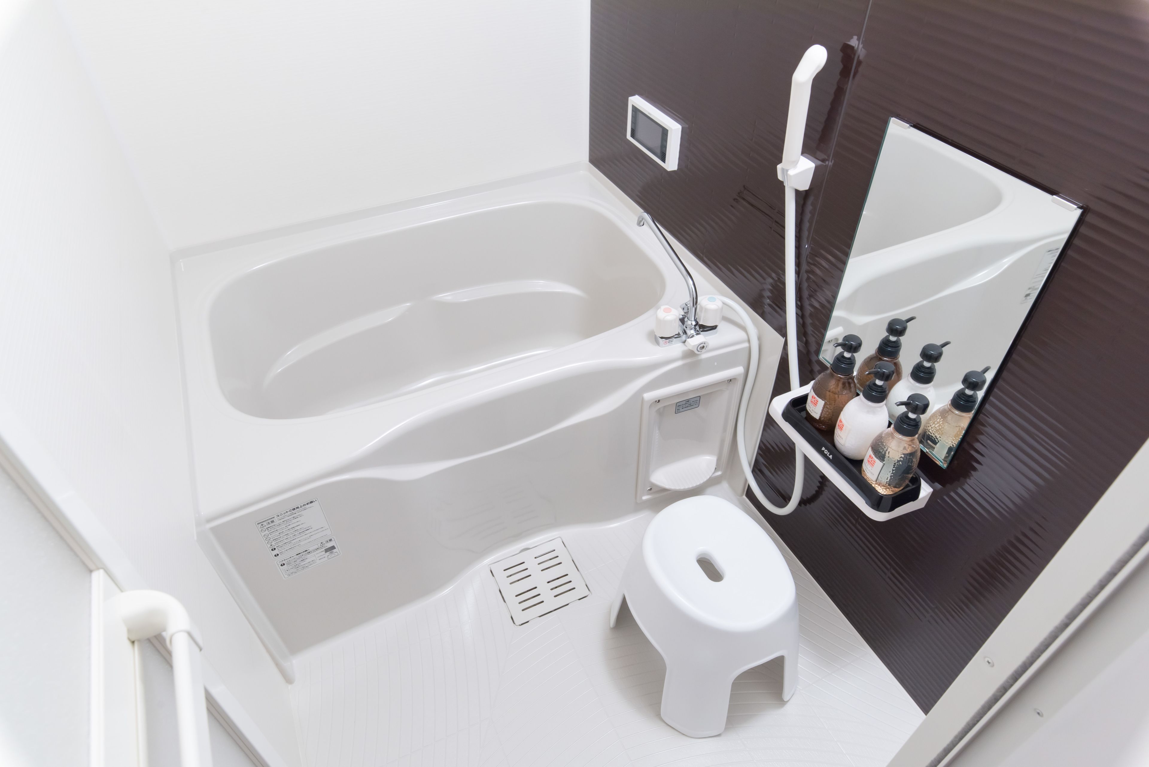 A modern bathroom with a white bathtub, a toilet, and a shower area.