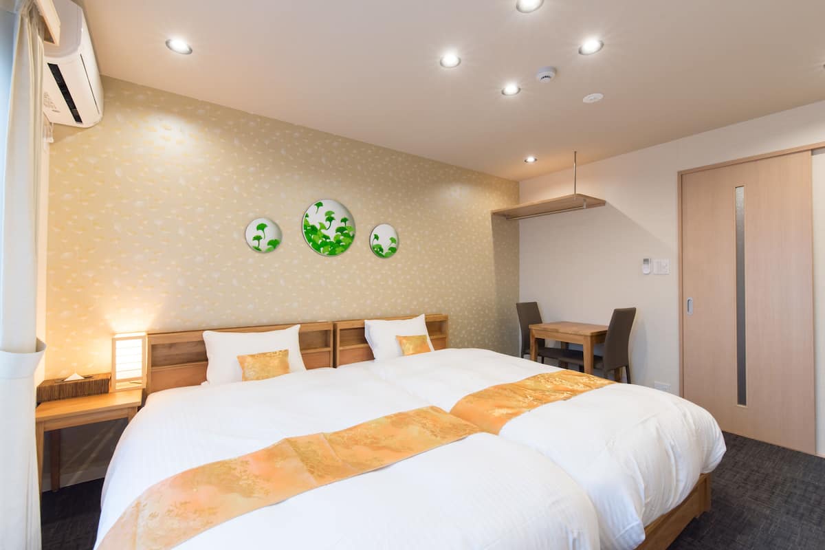 A hotel room with a large bed, bedside tables, a desk, and a chair.