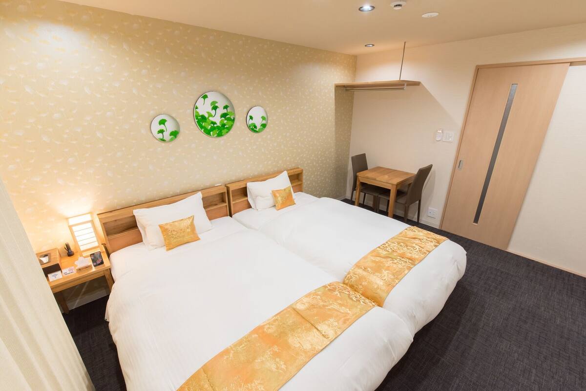 Quarto de hotel com uma cama grande, uma escrivaninha e uma cadeira.