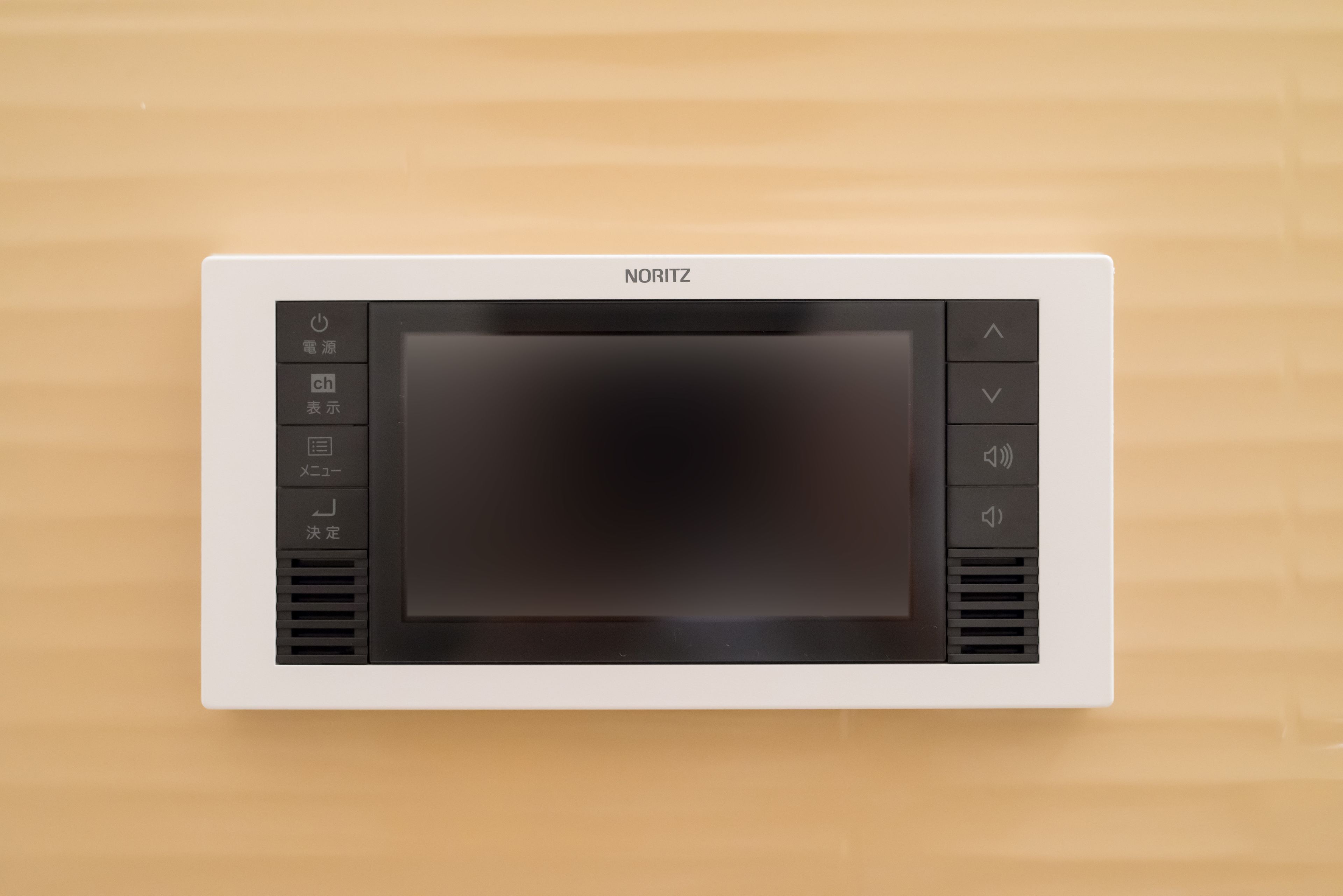 Un horno microondas NORITZ con pantalla digital y botones de control, instalado en una pared color beige.