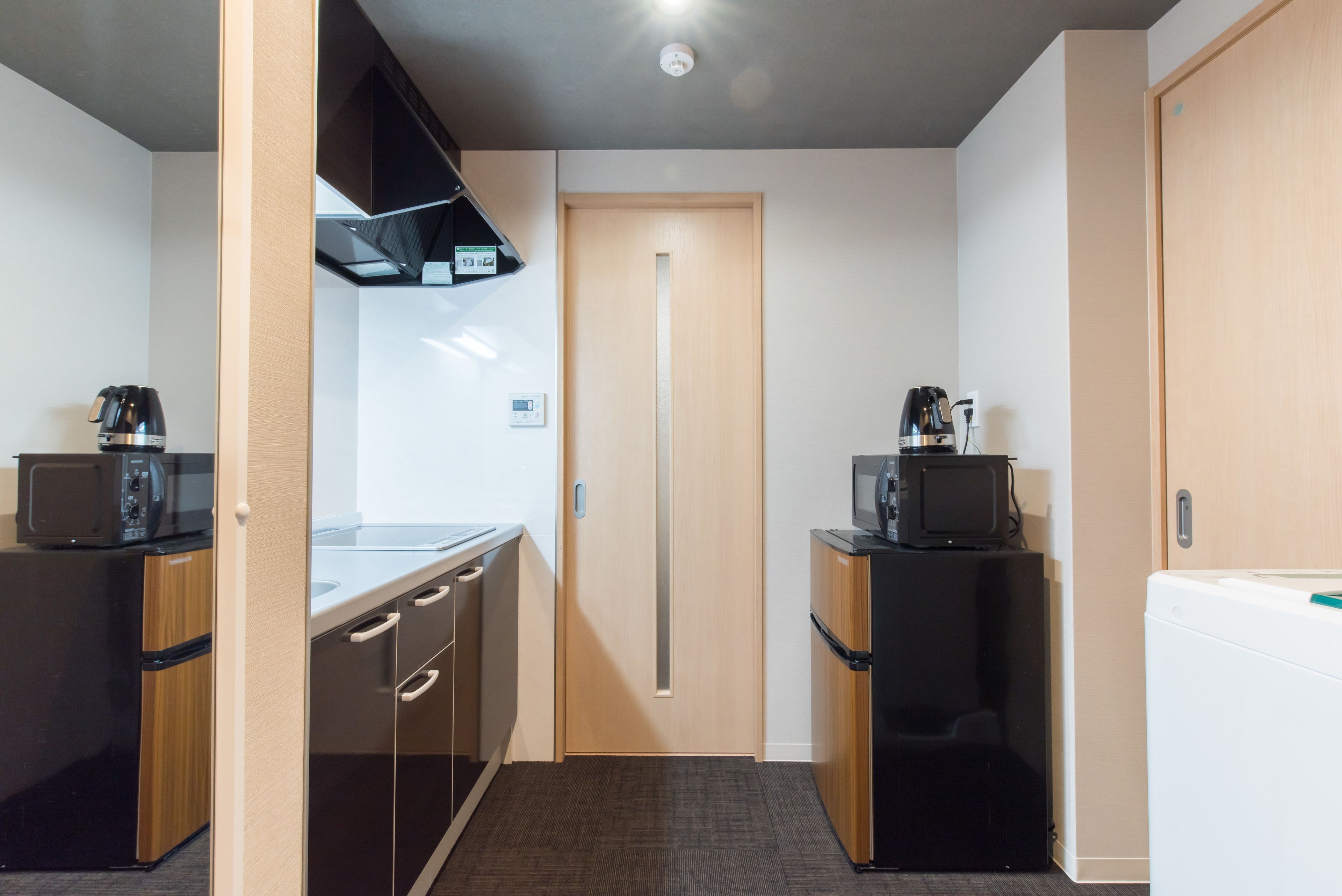 A compact kitchen with a microwave, coffee maker, and refrigerator.