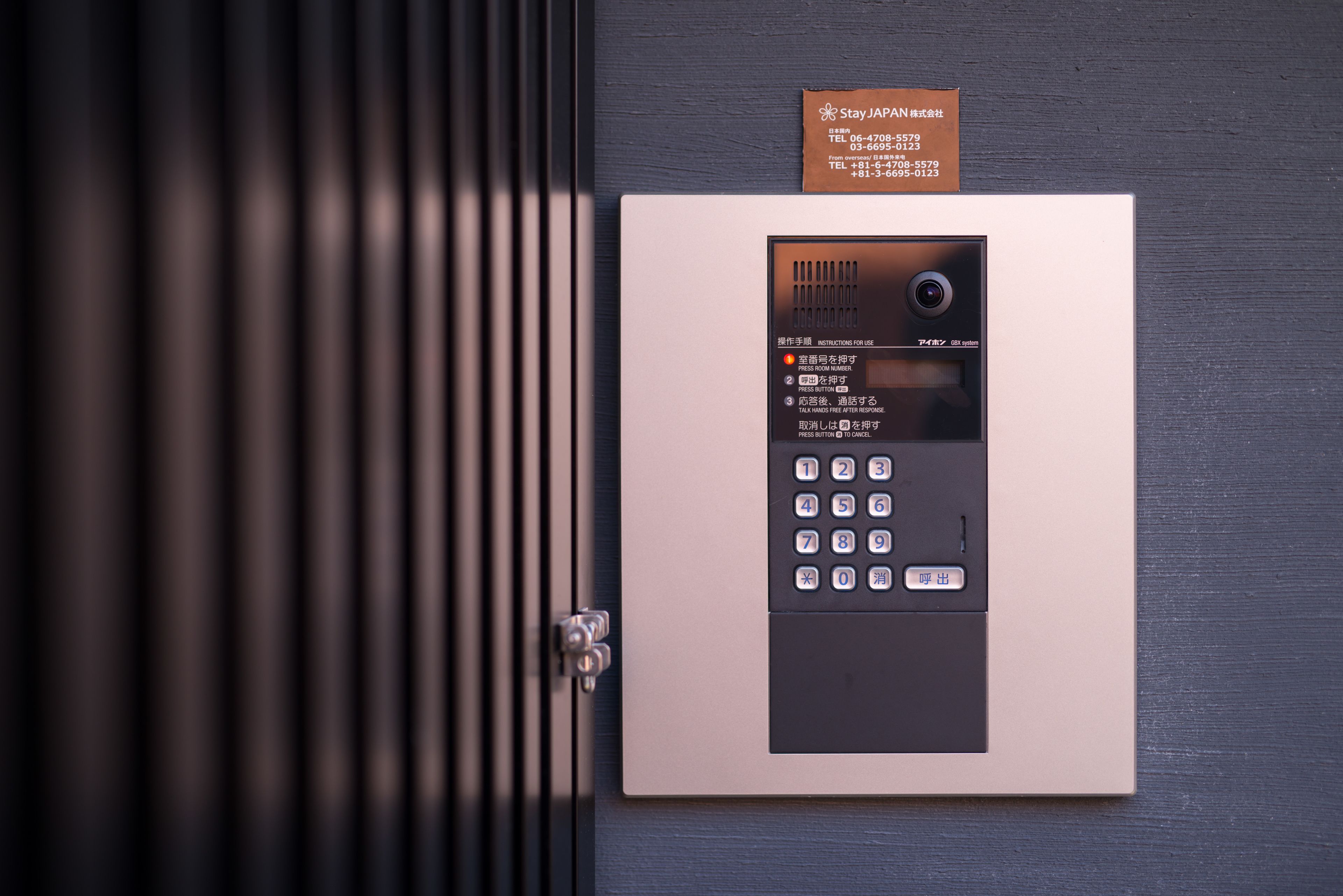 A security keypad with a sign above it.