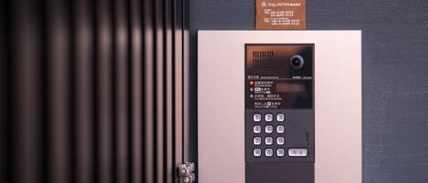 A security keypad with a sign above it.