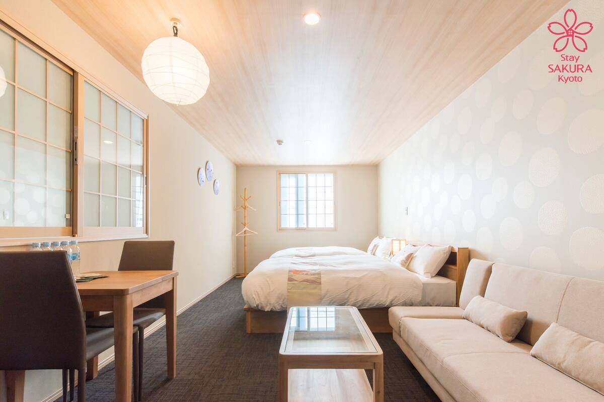 A hotel room with a bed, a sofa, a desk, and a chair.