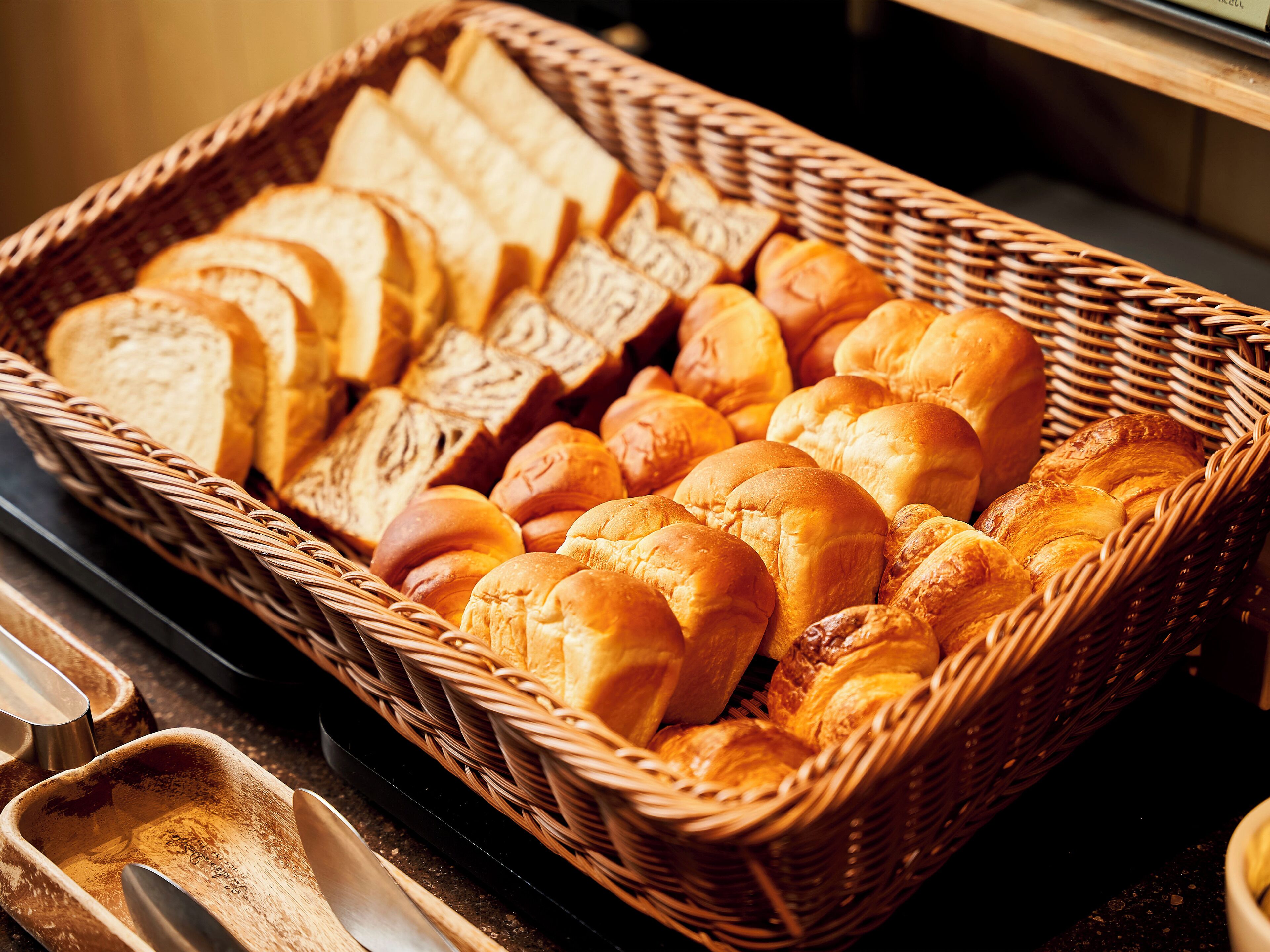 A wicker basket filled with various types of bread.
