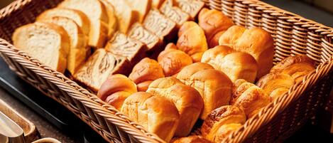 A wicker basket filled with various types of bread.