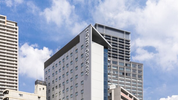A modern hotel building with a prominent 'HOTEL GACERY' sign, featuring a unique architectural design with a sloped roof and multiple balconies. - HOTEL GRACERY Osaka Namba (Osaka)