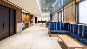 A modern interior with seating areas, a reception desk, and a large window. - HOTEL GRACERY Osaka Namba (Osaka)