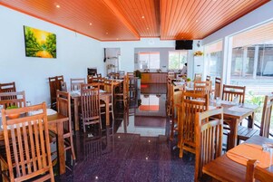 Un restaurante con muebles de madera, piso pulido y un cuadro en la pared.