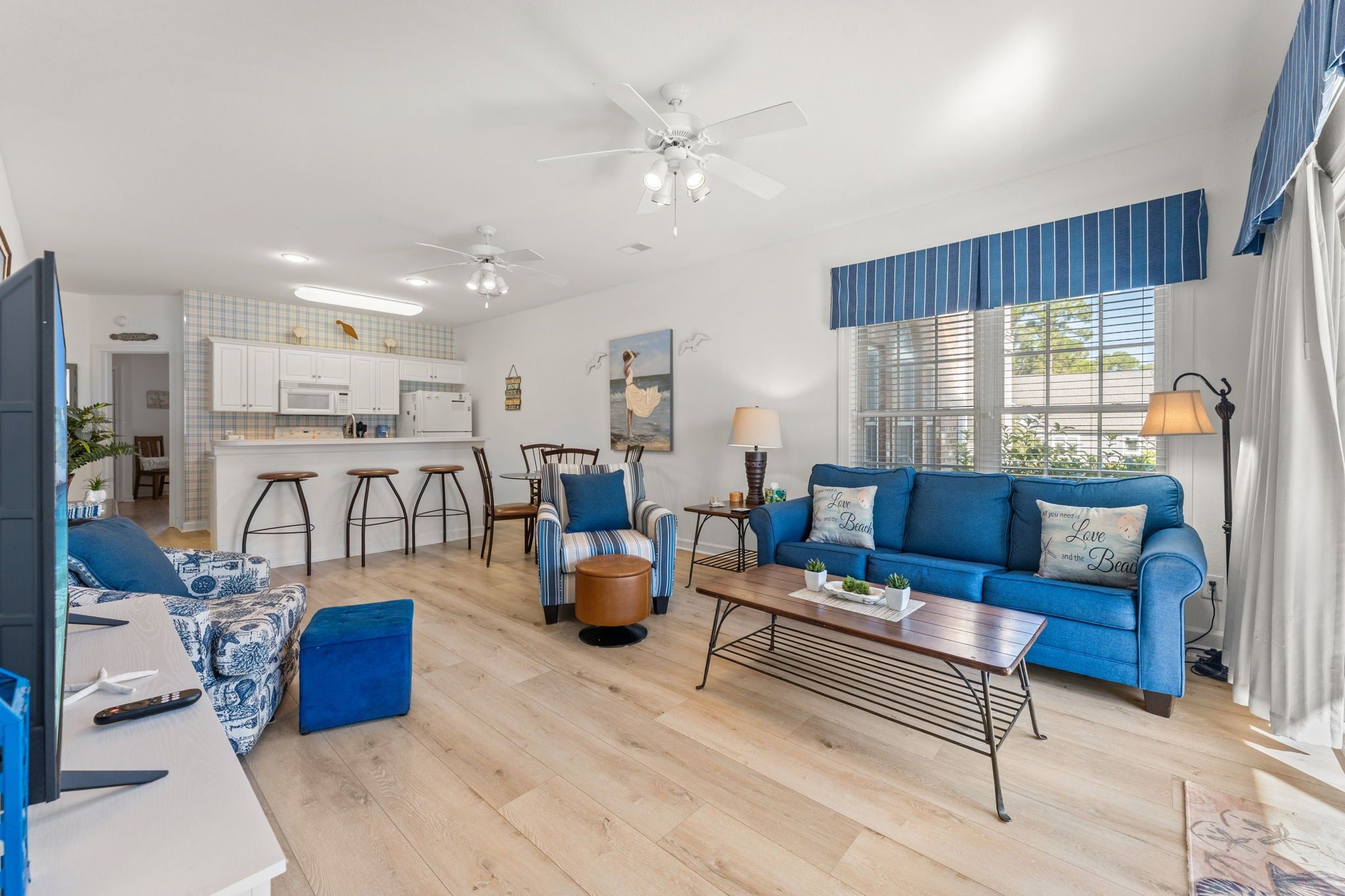 A modern living room with a blue sofa, a coffee table, and a TV.