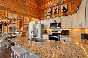 Una cocina con encimeras de granito, electrodomésticos de acero inoxidable y armarios de madera.