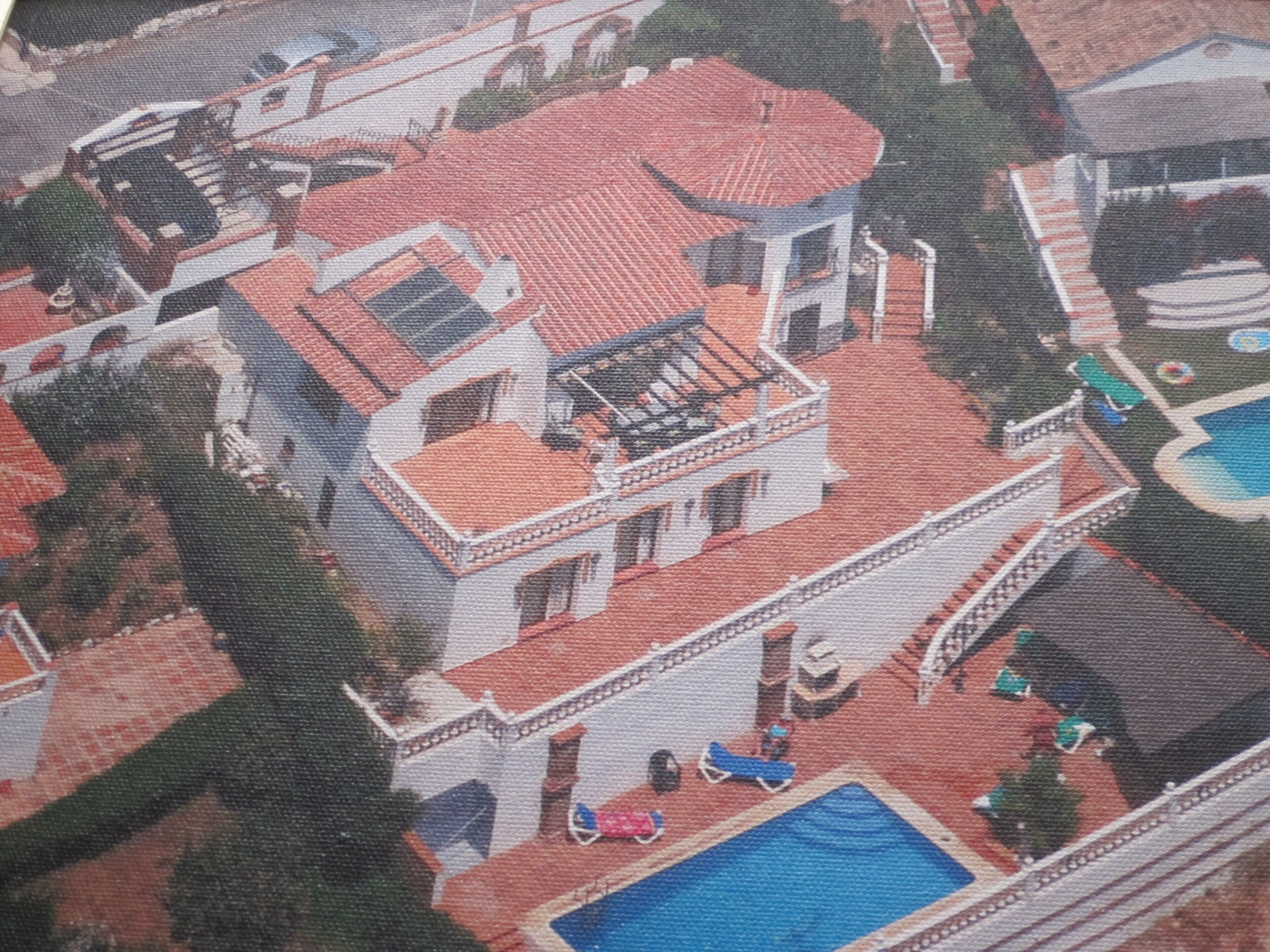 Un grand bâtiment à plusieurs étages, doté d’un toit recouvert de tuiles rouges, d’une piscine et d’un patio abrité.