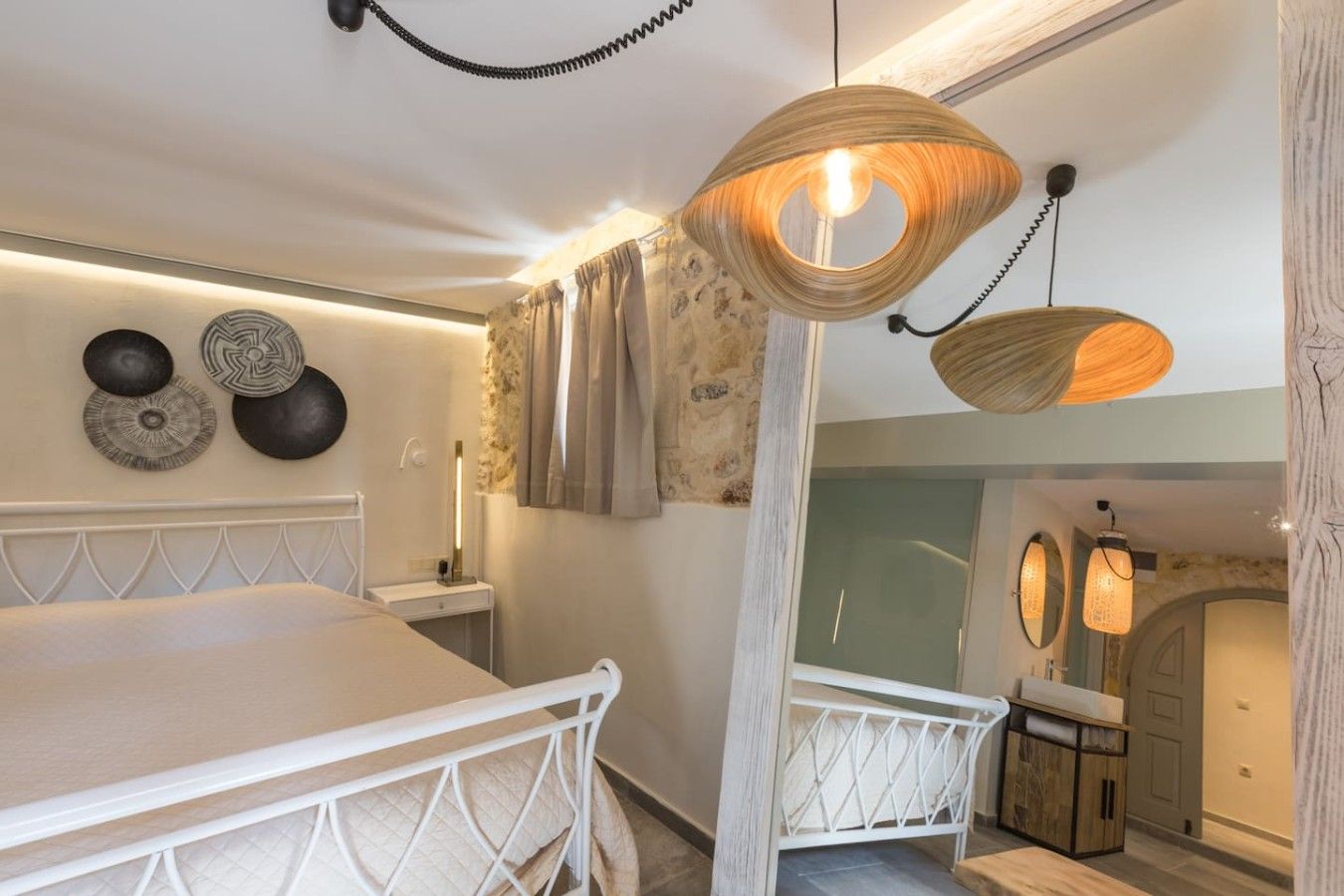 Ein Schlafzimmer mit Bett, Nachttisch, Wanddekoration und einer Pendelleuchte.