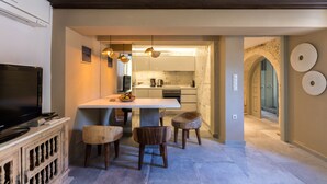Une cuisine moderne dotée d’un îlot central, de luminaires suspendus et d’un coin repas avec des tabourets en bois.