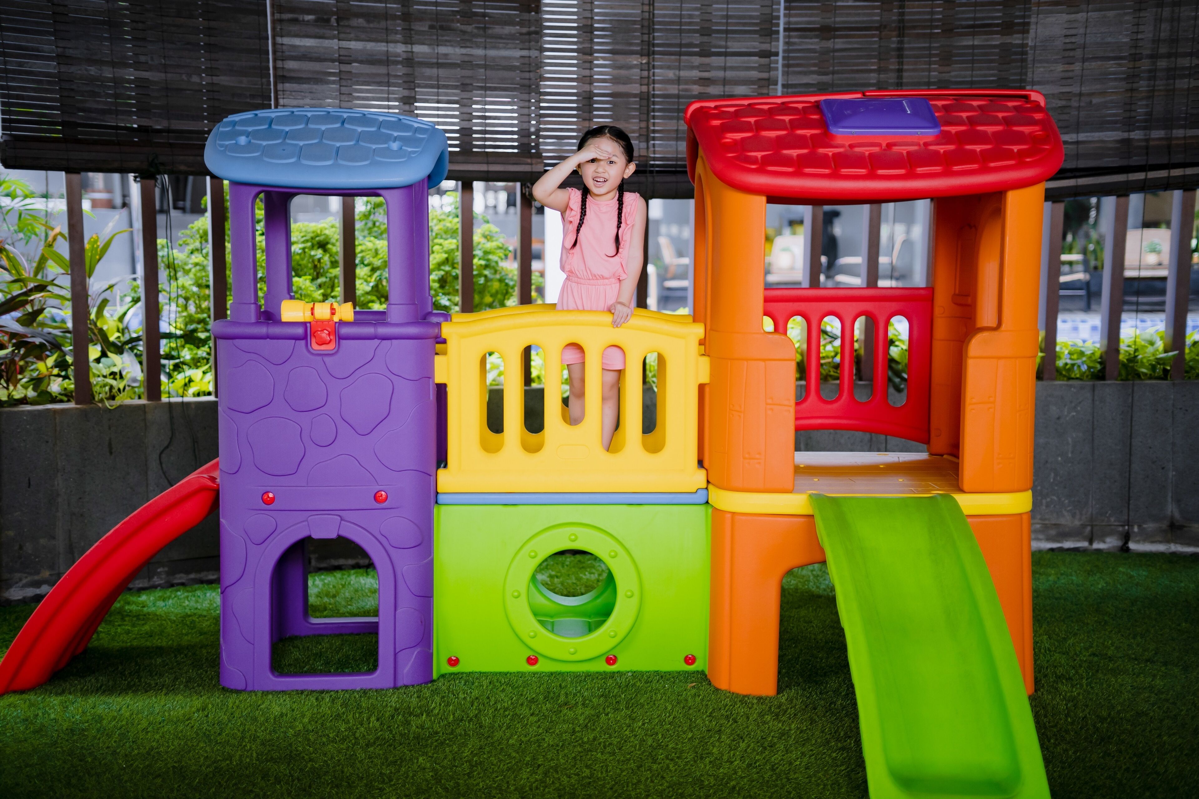 A child on a colorful play structure with a slide.