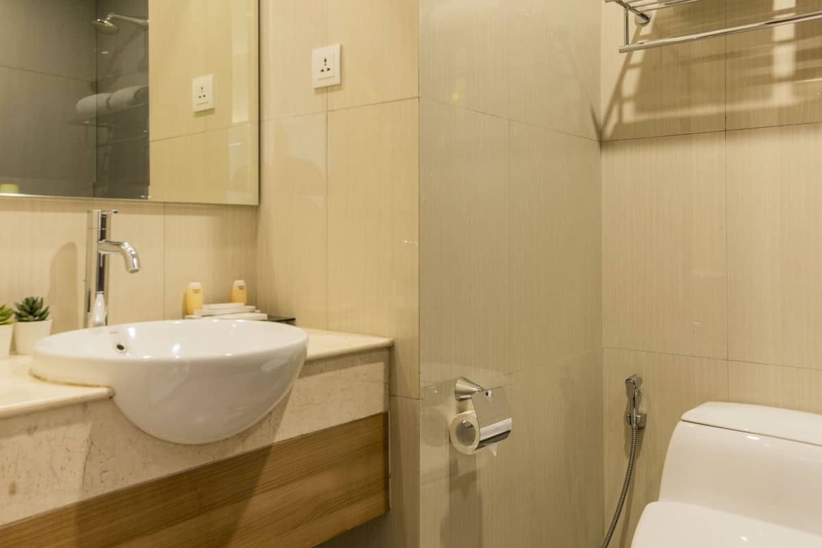 A modern bathroom with a sink, mirror, and toilet.