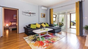 A modern living room with a sofa, coffee table, and a colorful rug. - 2 bedroom cozy apartment in Krasica (Krasica)
