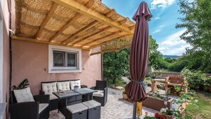 A covered patio with wicker furniture, a table, and an umbrella. - 2 bedroom cozy apartment in Krasica (Krasica)