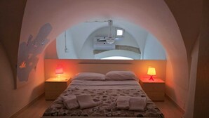 Ein Schlafzimmer mit einem Bett, zwei Nachttischen und einem Deckenventilator.