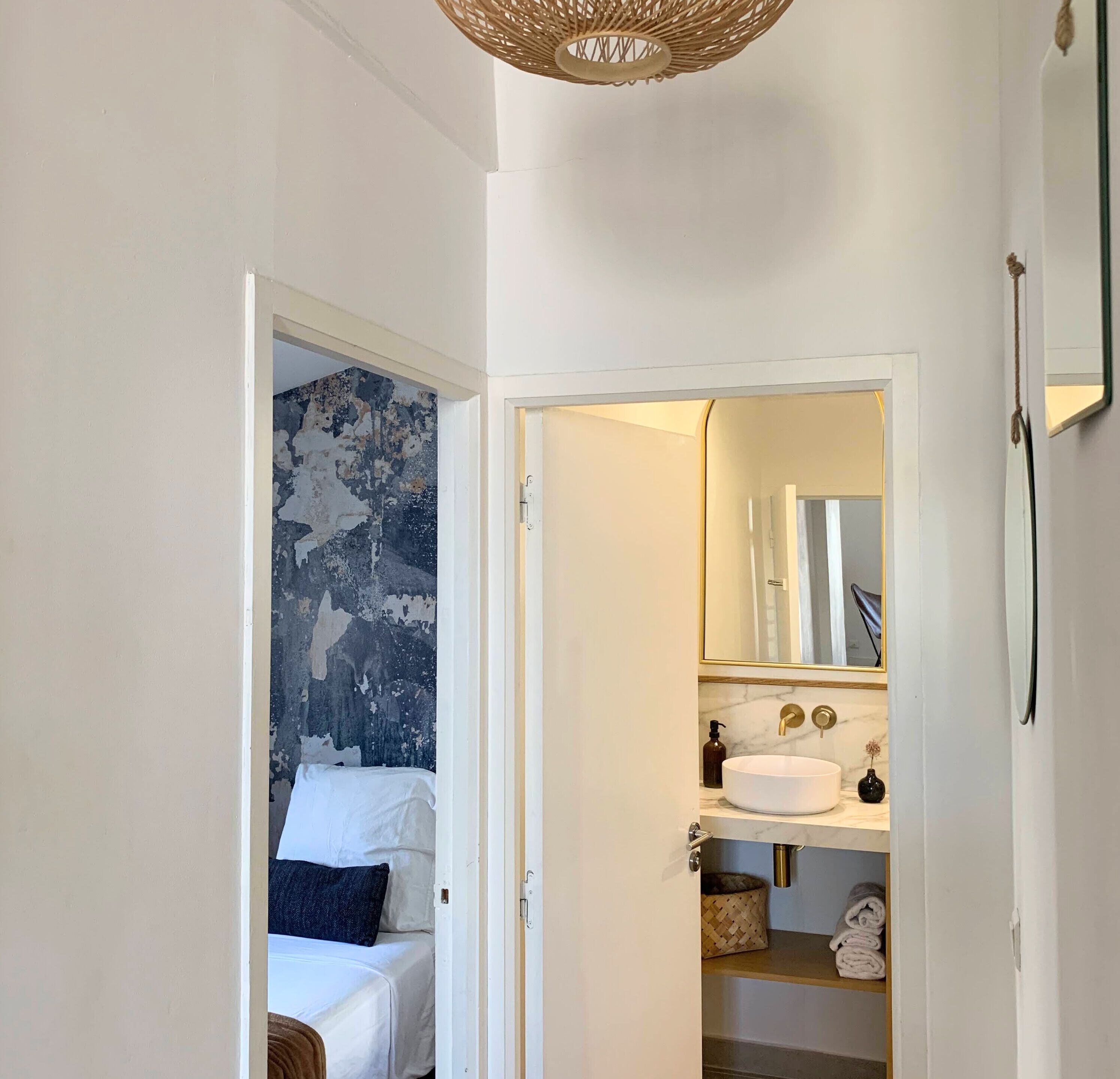 A bathroom with a white sink, a mirror, and a towel rack.