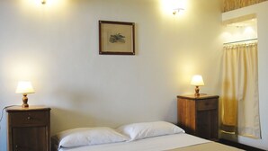 A hotel room with a bed, two bedside tables with lamps, a framed picture on the wall, and a window with curtains. - Charming apartment in Navona Square (Multiple rentals available) (Roma)