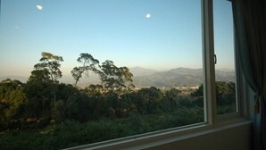 A room with a large window overlooking a mountainous landscape. - Warm House Hostel (Taichung)