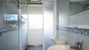 A bathroom with a toilet, sink, and a window. - Warm House Hostel (Taichung)