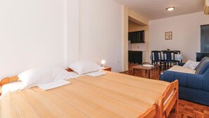 Une chambre à coucher comprenant un lit, un canapé, une petite table et un coin cuisine visible à travers une porte ouverte.