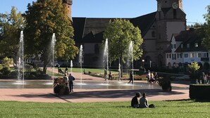A historic building with two towers, a central fountain, and a paved courtyard with people. - Small home in the spa area Freudenstadt (Freudenstadt)