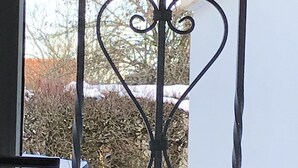 A metal gate with a decorative design, a white car parked behind it, and snow on the ground. - Small home in the spa area Freudenstadt (Freudenstadt)