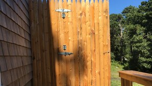 A wooden fence with a gate, a concrete pathway, and a wooden bench.