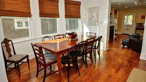 A dining area with a wooden table and chairs, large windows with blinds, and a view of the outside. - Fully updated, 2 Blocks from the Beach, Sleeps 12 (Cape May)