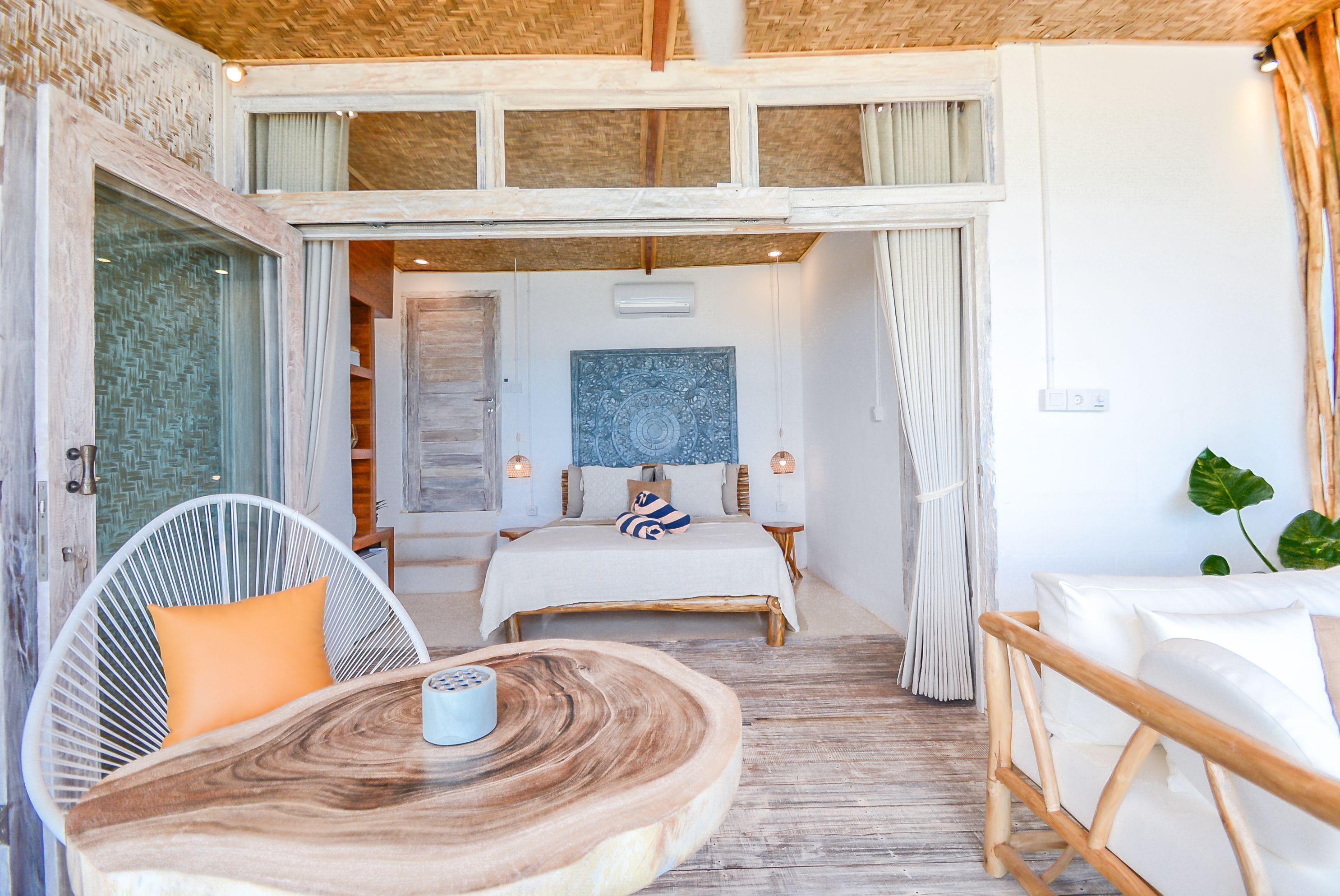 A bedroom with a bed, a wooden table, and a chair.