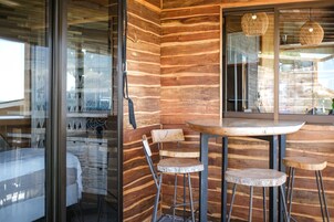 Un interior de madera con una mesa redonda y dos taburetes de bar.