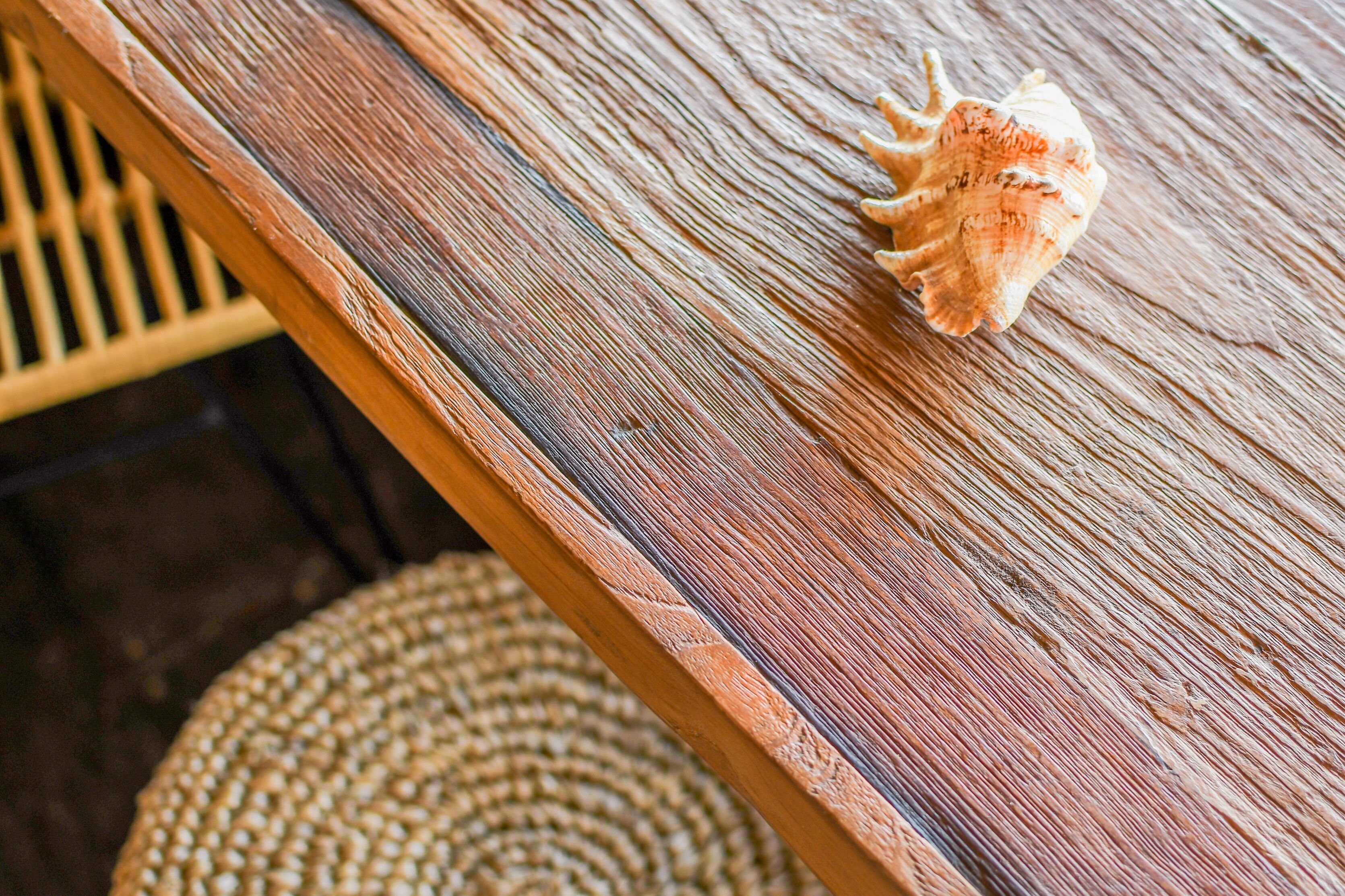 Una mesa de madera con una concha marina encima.