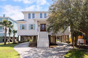 A two-story house with a front porch, a staircase leading to the entrance, and a pathway leading to the front door. - Upscale Retreat w/ Ocean Views + Pet Friendly (Folly Beach)