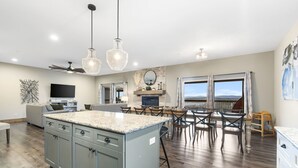 Cocina amplia con una isla central, comedor con sillas y un ventanal con vistas.