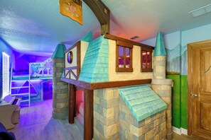 A room with a castle-themed playhouse, a bed, and a window. - Ultimate Getaway with Pool & Hot Tub, Stunning Views & All the Best Amenities (champions gate)