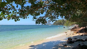A beach with clear turquoise water, a sandy shore, and rocky outcrops. - Celeste, 26 Bonito Street - Tranquil, Stylish & Pet friendly (Corlette)