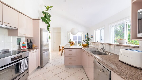 A modern kitchen with stainless steel appliances, a granite countertop, and a view of the outdoors.