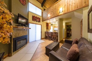 Una sala de estar acogedora con chimenea, televisor y un espacio de descanso cómodo.