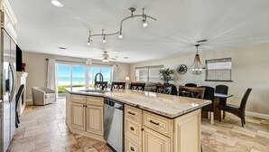 A spacious kitchen with a large island, modern appliances, and a view to the outdoors. - Direct Oceanfront Heavenly Retreat/FULLY LICENSED (Melbourne Beach)