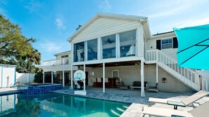Une maison à deux étages dotée d’une piscine, d’un terrain de basketball et d’un patio couvert.