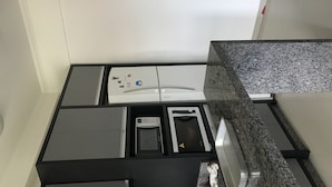 Eine Küche mit Mikrowelle, Backofen und kleinem Kühlschrank.