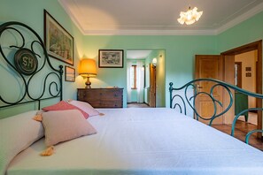 Un dormitorio con cama, cómoda y puerta que da a otra habitación.