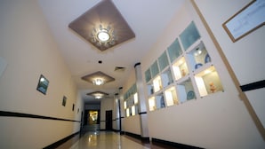 A hallway with a ceiling fan, recessed lighting, and a series of display cases with items. - Residence Park Hotel (Tashkent)