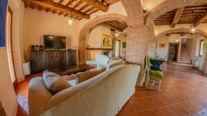 A spacious living area with a sofa, TV, and fireplace.