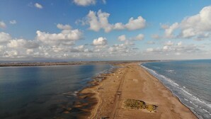 A wide beach with a clear sky and clouds.