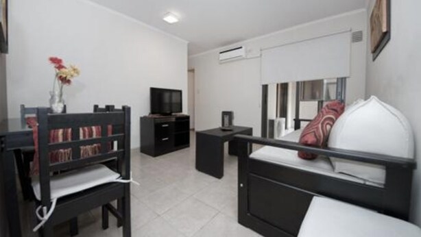 Une chambre d’hôtel moderne équipée d’un lit, d’un bureau, d’une chaise, d’une télévision et d’une petite table.