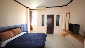 A bedroom with a bed, a television, a door, and an air conditioning unit. - Matini Amata (Phan Thong)